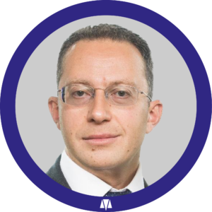 תמונת דיוקן של עו"ד קונסטנטין קרול (Konstantin Kroll) בתוך מסגרת עגולה כחולה.